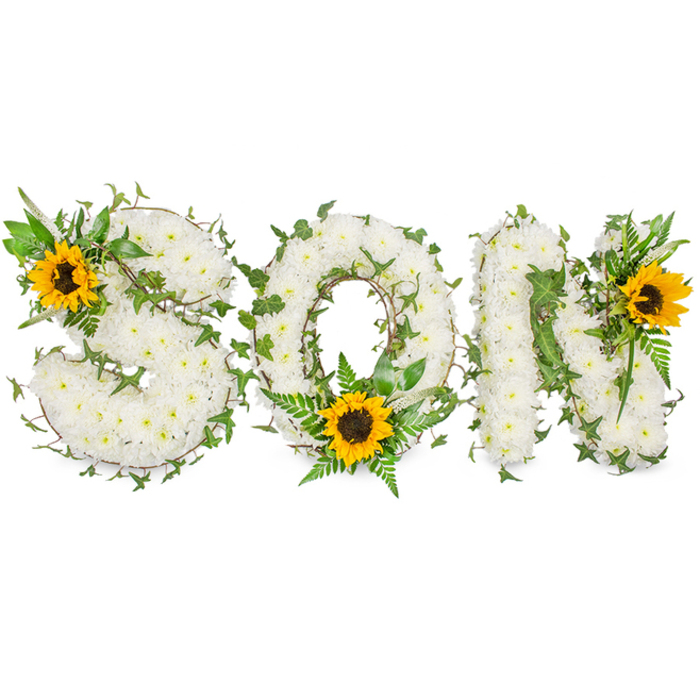 A sculpted floral tribute that spells SON in strong capital letters, shown against a pure white studio background so every detail is visible: each letter is densely cloaked in hundreds of small, pristine white chrysanthemums whose clustered petals form a soft, pillowy surface that reads calm and reverent. Intertwining throughout the white canvas are deep green ivy vines with characteristic lobed leaves; these vines wrap and thread through each letter, adding depth, line, and a living rhythm. Additional greenery - fern fronds and sharper-pointed leaf sprigs - is layered to create pockets of shadow and to separate the letter forms subtly, giving the whole composition a deliberate, handcrafted architecture. Three large sunflowers are placed as warm beacons: one on the S's upper-left curve, one at the lower arc of the O where it rests among verdant ferns, and one adorning the N's upper-right corner. Their golden-yellow rays and textured dark-brown discs introduce an uplifting contrast that suggests light and remembrance amid mourning. The photograph's clean lighting emphasizes texture and volume, allowing the chrysanthemums' softness, the sunflowers' coarse centers, and the ivy's glossy sheen to register clearly. Designed for memorial or funeral use, and mindful of St James's local tastes and the dignified settings around Regent Street and Green Park, this piece radiates respectful sentiment - an eloquent, personalized way to honour a beloved son with a balance of white serenity, verdant life, and sunflower warmth.